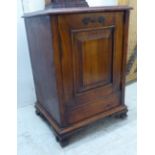 A late Victorian walnut pot cupboard, enclosed by a panelled door,