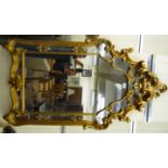 A modern rococo design mirror, in an ornate scrolled,
