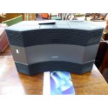 A Bose Acoustic Wave Music System with instructions and a remote control LAM