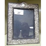 A Victorian style glazed silver photograph frame, embossed with flora, clover leaves and scrolls,