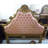 A 20thC 'antique' inspired gilded headboard with a pink button upholstered panel 68''w BSR