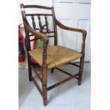 A mid 19thC oak framed elbow chair with a bobbin turned and spindled back,