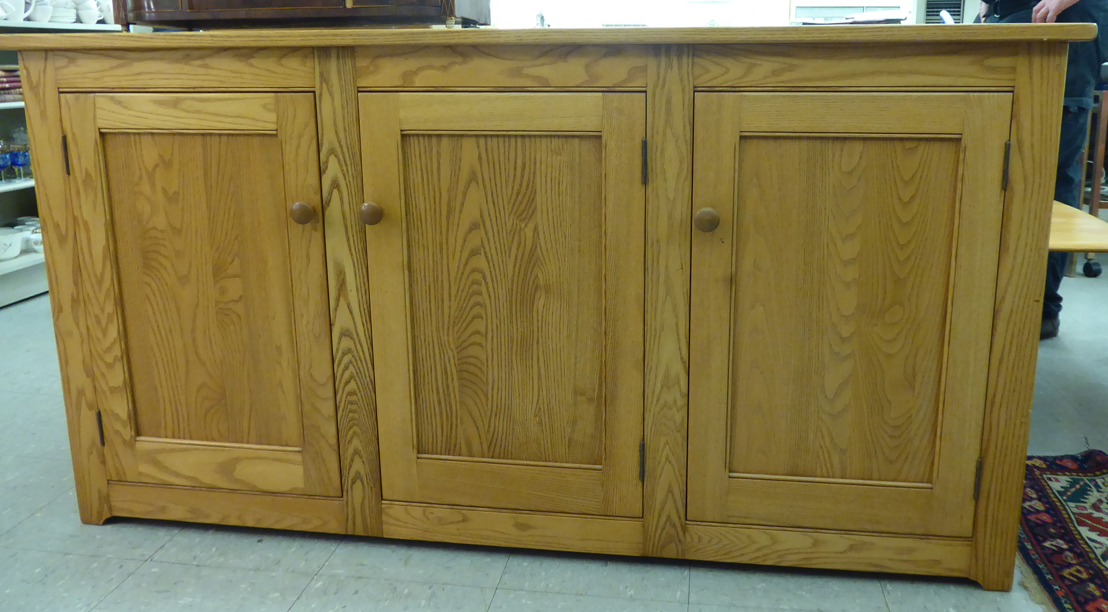 An Ercol elm sideboard with three panelled doors,