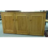 An Ercol elm sideboard with three panelled doors,