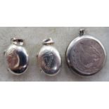 A pair of silver engraved miniature oval lockets;