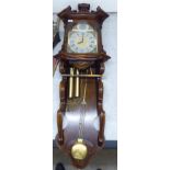 A 20thC Continental stained pine cased wall clock with an upstand cornice,