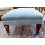 A Greengate footstool with a blue fabric upholstered top, raised on mahogany square,