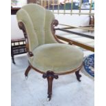 A late Victorian walnut framed nursing chair with a green fabric upholstered back and seat,