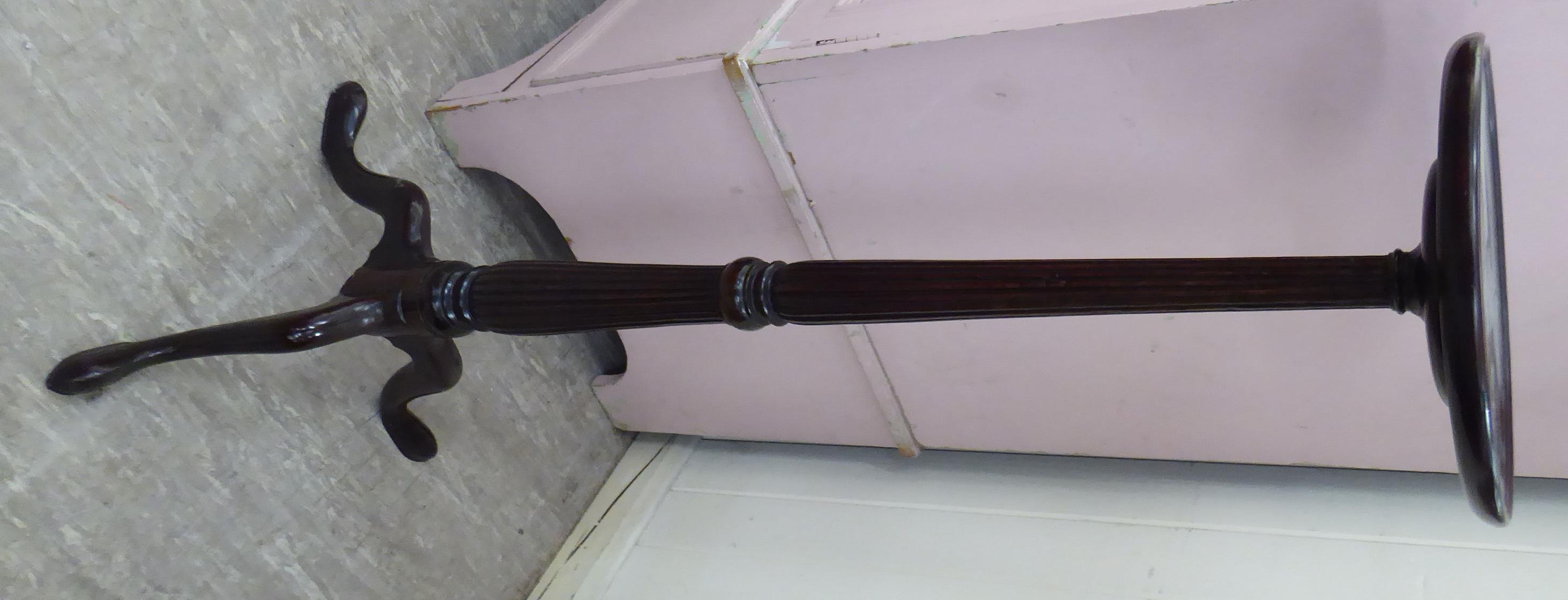 A modern mahogany finished torchere, the circular top over a turned, reeded column,