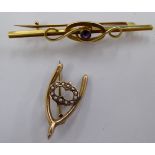 An 'antique' 15ct gold amethyst set bar brooch; and a wishbone brooch,