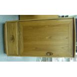 An Ercol elm hi-fi cabinet with a hinged lid, over a door and drawer,