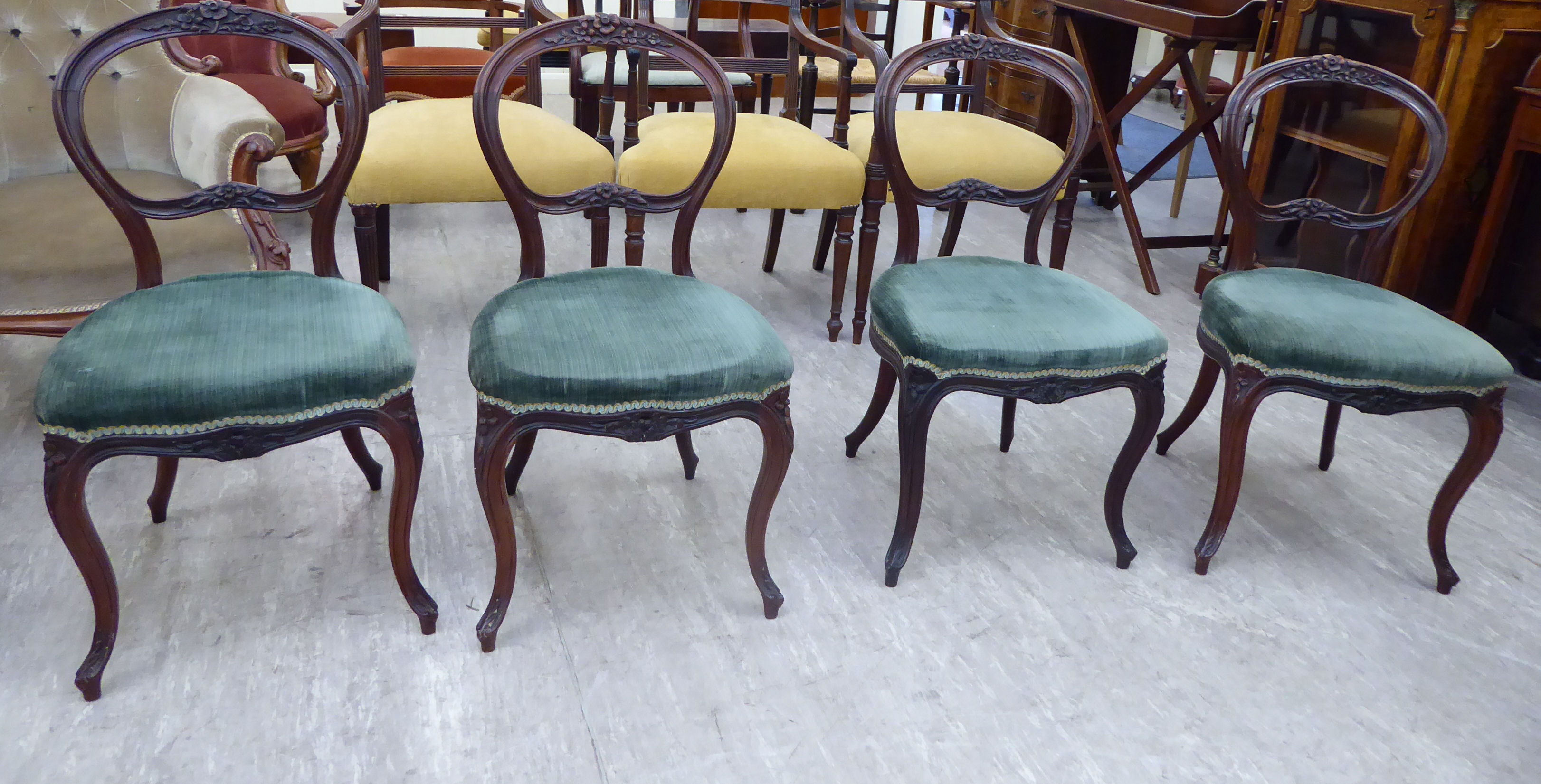 A set of four late Victorian walnut framed balloon back dining chairs,