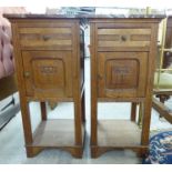 A pair of early 20thC French light oak bedside cabinets, each having a mottled, iron red marble top,