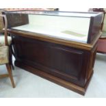 A modern retailer's mahogany finished display counter with a lockable,