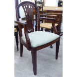 A George III Sheraton design mahogany framed dining chair, the crest carved with husk motifs,