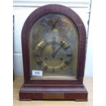 An early 20thC mahogany cased bracket clock, having a round arch top and straight sides,