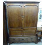 A late 18th/early 19thC country made panelled oak press cupboard with a pair of doors,