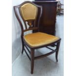 An Edwardian satinwood inlaid mahogany framed salon chair with a shield shaped back and a gold