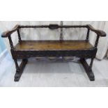 A late 19thC carved oak two person hall seat with a low level back,