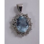 An 18ct white gold oval aquamarine and diamond set pendant