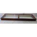 An early 20thC retailer's mahogany counter-top display cabinet, enclosed by a pair of angled,