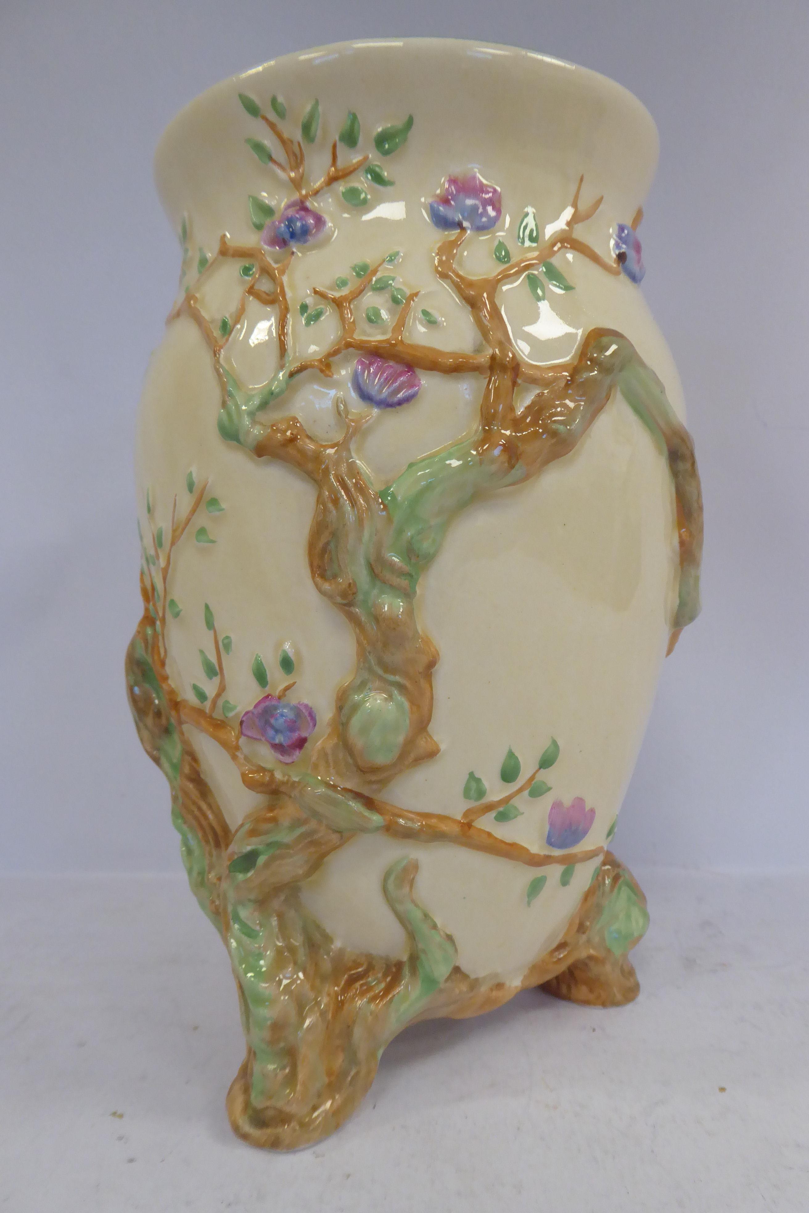 A Clarice Cliff cream glazed china vase of ovoid form, having a flared rim,