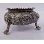 An early Victorian silver salt cellar of squat, bulbous form, embossed and chased with flora,