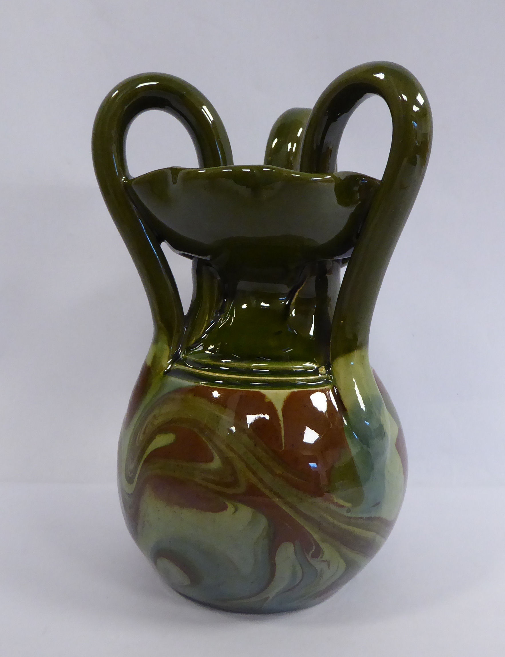 A Barum ware green and brown, part marbelised glazed pottery jug of bulbous form with a narrow neck,