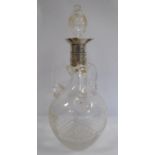 An Edwardian slice cut glass spirit decanter of ovoid form with triple strap handles, an applied,