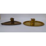 Two similar Arts & Crafts brass deskstands, each comprising a covered inkwell, on a tray base,