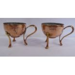 A pair of Art Nouveau WMF spot-hammered copper and rivetted brass miniature cups with stylised loop