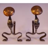 A pair of Arts & Crafts scrolled wrought iron and copper fire dogs with spot-hammered decoration