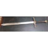 A copy of a medieval broadsword with a ribbed handgrip and brass hilt,