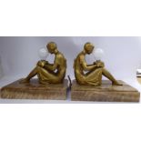 A pair of Art Deco gilt painted spelter table lamps, fashioned as seated young women,