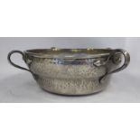 An early 20thC Arts & Crafts inspired English Pewter spot-hammered bowl of shallow ogee form with