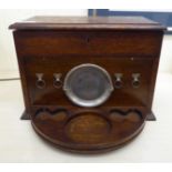 A 1920s oak cased smoker's compendium with straight sides and a hinged lid,