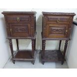 A pair of late 19th/early 20thC French stained and carved oak bedside cabinets,