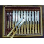 A late Victorian set of twelve dessert forks and knives with floral engraved, silver plated blades,