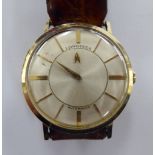 A 1950s Longines Mystery yellow metal cased wristwatch, the automatic movement faced by baton dial,