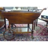 A modern mahogany finished cocktail wagon with fall flaps, raised on ring turned uprights,