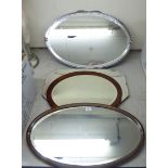 Four dissimilar early 20thC mirrors with variously shaped plates,