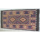 A North African inspired rug with two central diamond shaped motifs bordered by stylised designs on