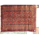 A Bokhara rug with three columns of eight guls bordered by stylised designs on a red ground 42'' x