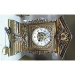 A late 19th/early 20thC decoratively cast brass cased mantel clock with a simulated, tiled,