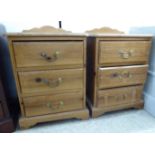 A pair of modern waxed pine three drawer bedside chests with brass bail handles,