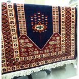 A Persian prayer mat with stylised designs on a blue ground 32'' x 47'' S