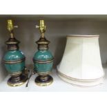 A pair of modern 'antique' finished brass and green enamelled pedestal vase design table lamps