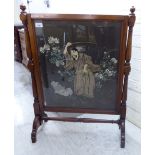 An early 20thC glazed mahogany framed firescreen, set with an embroidered silk panel,