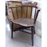 A 1920s stained beech and elm framed captains' design chair with a round, level,