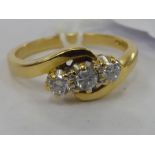 An 18ct gold three claw set diamond crossover ring 11